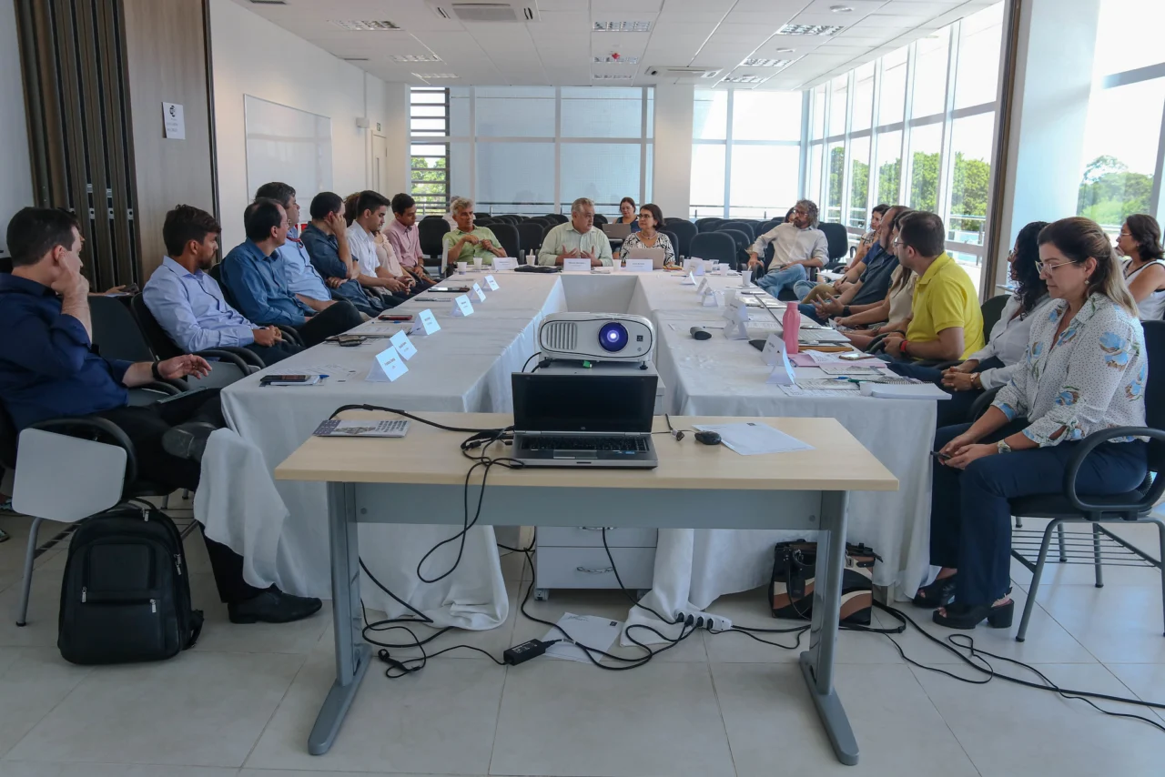 Integrantes do LARIISA em reunião de trabalho ao redor de uma mesa, com projetor e notebook.